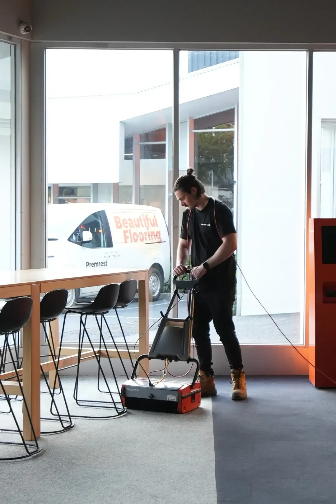 A Premrest team member cleaning a commercial floor.